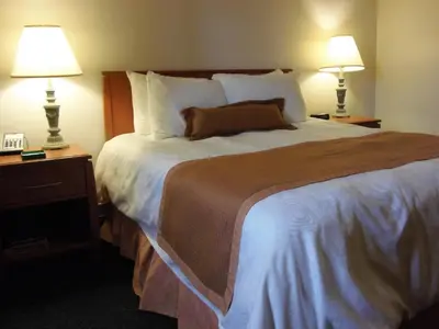 a hotel room with a large bed with two lamps at Rosslyn Inn & Suites in Edmonton
