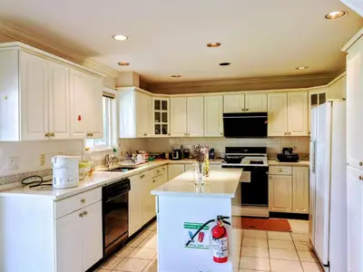 a kitchen with white cabinets and black appliances at Great Guest Suite in a Gorgeous House in New Westminster