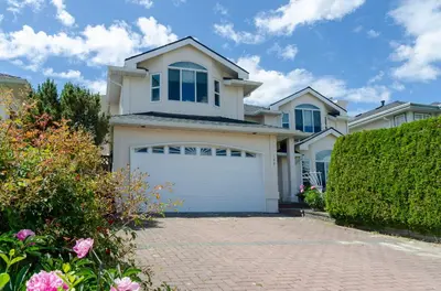a large white house with a garage at Great Guest Suite in a Gorgeous House in New Westminster
