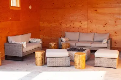 a patio with two chairs and a couch and some logs at Red Cariboo Apartments in Anahim Lake