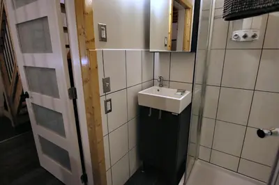a bathroom with a sink next to a door at Red Cariboo Apartments in Anahim Lake