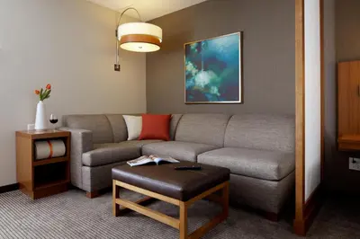 a living room with a couch and a table at Hyatt Place Calgary Airport in Calgary