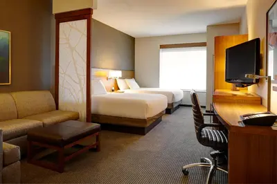 a hotel room with two beds and a television at Hyatt Place Calgary Airport in Calgary