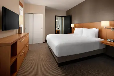 a hotel room with a large bed and a flat screen tv at Hyatt Place Calgary Airport in Calgary