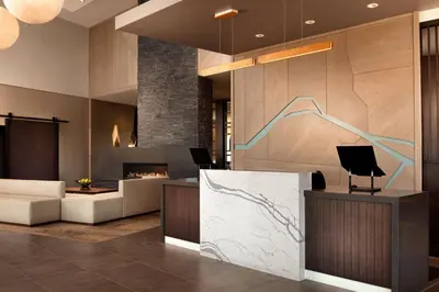 a lobby of a hotel with a desk with a drawing on the wall at Hyatt Place Calgary Airport in Calgary