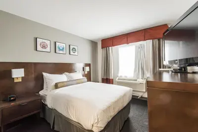 a hotel room with a bed and a television at Edgewater Hotel in Whitehorse