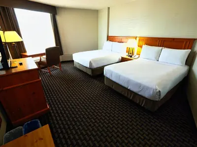 a hotel room with two beds and a desk at Continental Inn & Suites in Edmonton