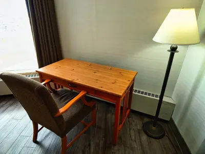 a desk with a lamp and a chair next to a table at Continental Inn & Suites in Edmonton