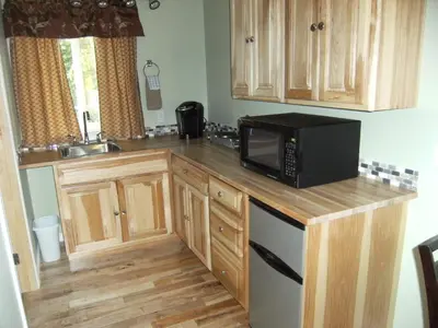 a kitchen with wooden cabinets and a microwave on a counter at Parkside Inn in Haines Junction