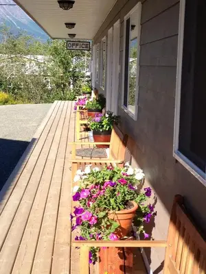 a row of benches with flowers on a porch at Parkside Inn in Haines Junction
