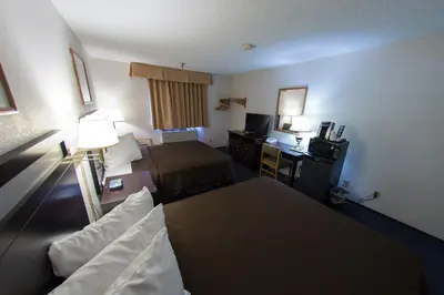 a hotel room with two beds and a television at Super 8 by Wyndham Williams Lake BC in Williams Lake