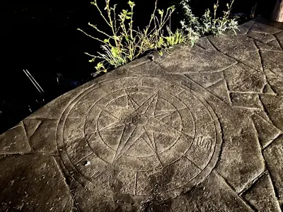 a stone circle with a pentagram on the ground at Waterfront Hot Tub Firepit King Bed - 6H in Ucluelet