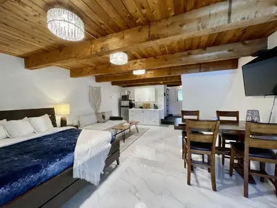 a bedroom with a bed and a dining room at Waterfront Hot Tub Firepit King Bed - 6H in Ucluelet