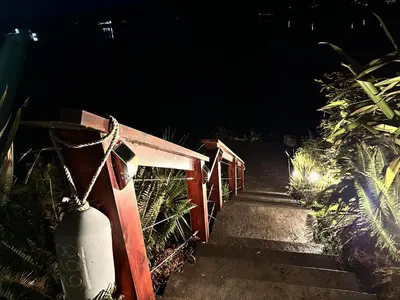 a set of stairs leading up to a gate at night at Oceanfront Room With Hot Tub & Firepit in Ucluelet