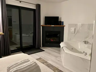 a bathroom with a bath tub and a fireplace at Oceanfront Room With Hot Tub & Firepit in Ucluelet