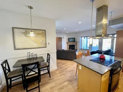 a kitchen and a living room with a table at Marina View On The Harbour in Ucluelet
