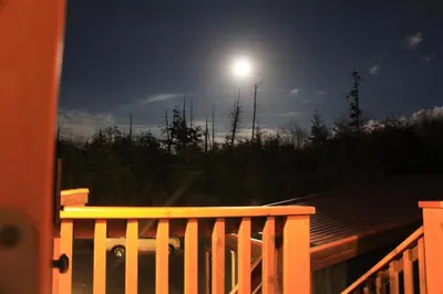 a full moon over a deck with a fence at Top-Floor Villa With Pacific Ocean Views Bbv in Ucluelet