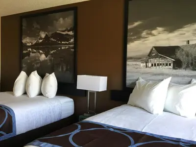 a hotel room with two beds and a painting on the wall at Super 8 by Wyndham Spruce Grove in Spruce Grove