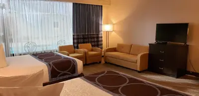 a hotel room with a bed chair and a television at Super 8 by Wyndham Spruce Grove in Spruce Grove