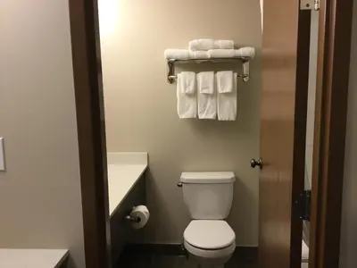 a small bathroom with a toilet and towels at Super 8 by Wyndham Spruce Grove in Spruce Grove