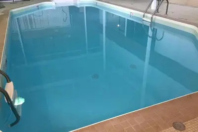 a large swimming pool with blue water at Super 8 by Wyndham Spruce Grove in Spruce Grove