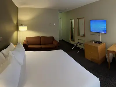 a hotel room with a large bed and a couch at Heritage Inn Hotel & Convention Centre - Cranbrook in Cranbrook