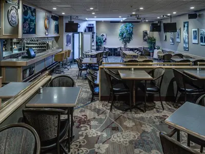 a restaurant with tables and chairs and a bar at Heritage Inn Hotel & Convention Centre - Cranbrook in Cranbrook
