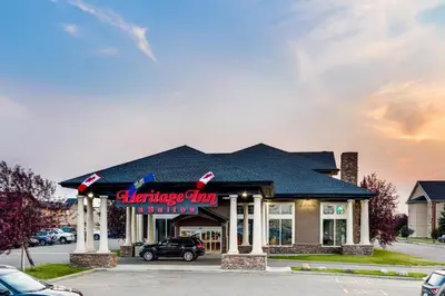 a building with a sign for a restaurant at Heritage Inn & Suites - Brooks in Brooks