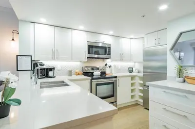 a white kitchen with white cabinets and appliances at Sunpath by Outpost Whistler in Whistler