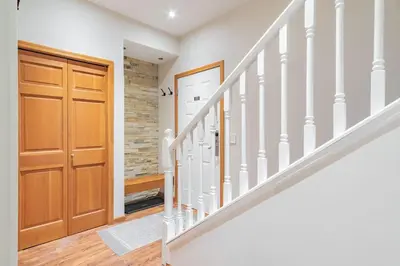 a hallway with a wooden door and stairs at Northstar by Outpost Whistler in Whistler