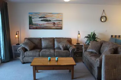 a living room with two couches and a coffee table at Siennas Harbour House in Tofino