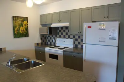 a kitchen with a white refrigerator and a sink at Siennas Harbour House in Tofino