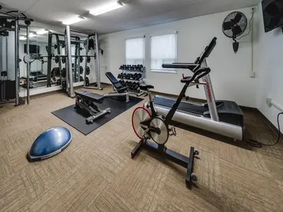 a gym with several treadmills and exercise machines at Heritage Inn Hotel & Convention Centre - Brooks in Brooks
