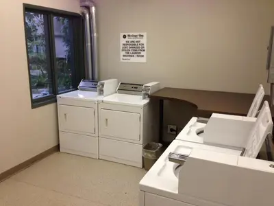 a room with three machines and a table and a window at Heritage Inn Hotel & Convention Centre - Brooks in Brooks