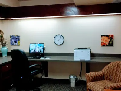 an office with a desk with a laptop and a clock at Super 8 by Wyndham High Level AB in High Level