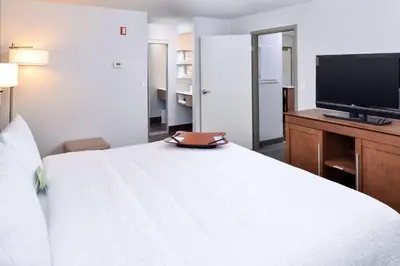 a hotel room with a bed and a flat screen tv at Hampton Inn & Suites by Hilton Calgary University NW in Calgary
