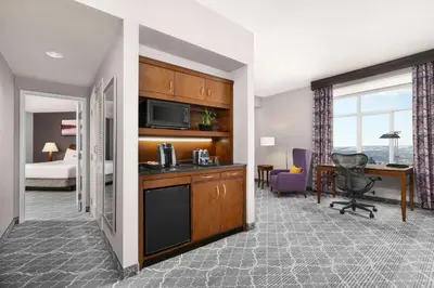 a hotel room with a kitchen and a bedroom at Hilton Garden Inn Calgary Airport in Calgary