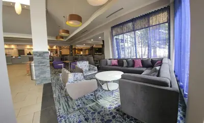 a lobby with couches and a table and chairs at Hilton Garden Inn Calgary Airport in Calgary