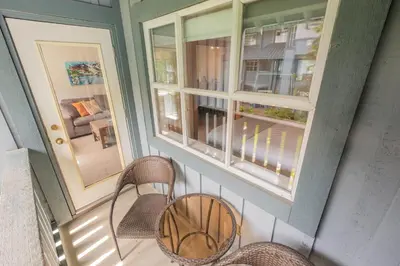 a balcony with two chairs and two windows at Glaciers Lodge by Outpost Whistler in Whistler