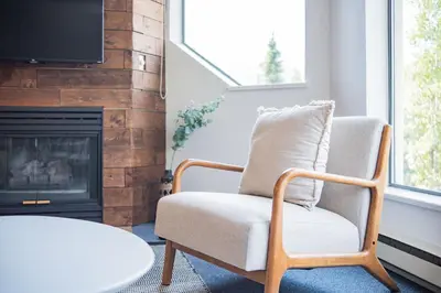 a living room with a chair and a fireplace at Marquise by Outpost Whistler in Whistler