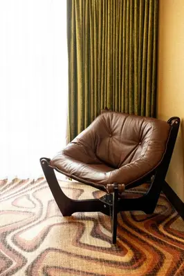 a brown leather chair sitting in front of a window at Hotel Zed Victoria in Victoria