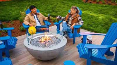 two people sitting in chairs around a fire pit at Hotel Zed Victoria in Victoria