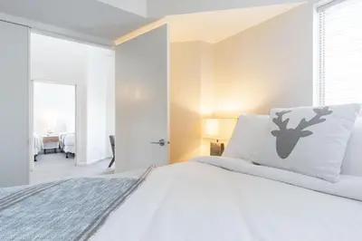 a bedroom with a white bed with a reindeer pillow at Tyndall Stone by Outpost Whistler in Whistler