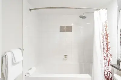 a white bathroom with a tub and a shower at Tyndall Stone by Outpost Whistler in Whistler