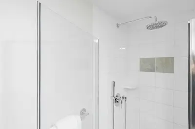 a bathroom with a shower with a glass door at Tyndall Stone by Outpost Whistler in Whistler