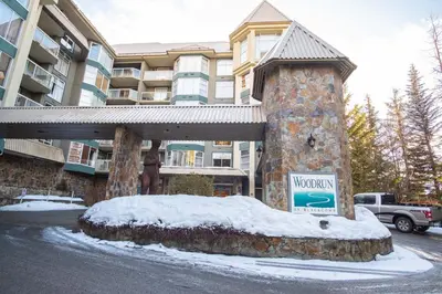 a sign in the snow in front of a building at Woodrun by Outpost Whistler in Whistler
