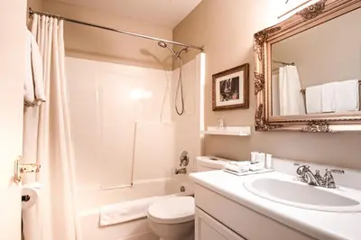 a bathroom with a sink and a toilet and a mirror at Courthouse Inn Revelstoke in Revelstoke