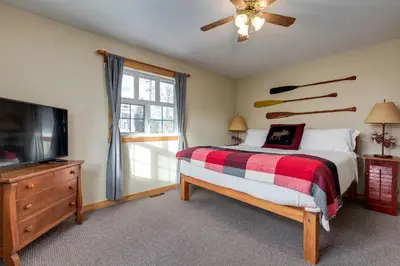 a bedroom with a bed and a flat screen tv at Courthouse Inn Revelstoke in Revelstoke