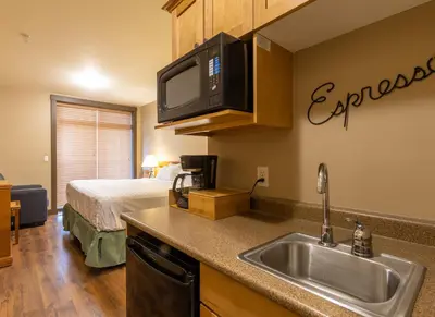 a kitchen with a sink and a bed in a room at Palliser Lodge — Bellstar Hotels & Resorts in Golden