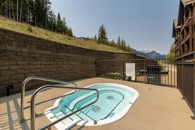 a jacuzzi bath tub with a metal hand rail at Palliser Lodge — Bellstar Hotels & Resorts in Golden